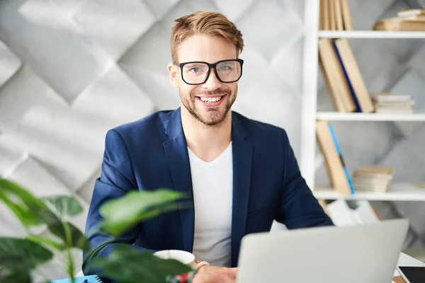 Hombre de negocios contento trabajando en la oficina con placer — Foto de Stock