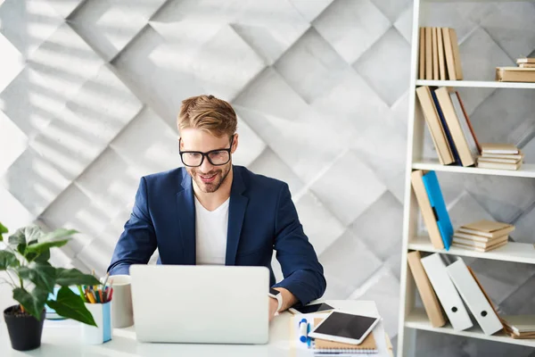 Sonriente hombre trabajando en el escritorio con alegría —  Fotos de Stock