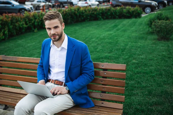 Cheerful businessman using laptop in park — Stock Photo, Image