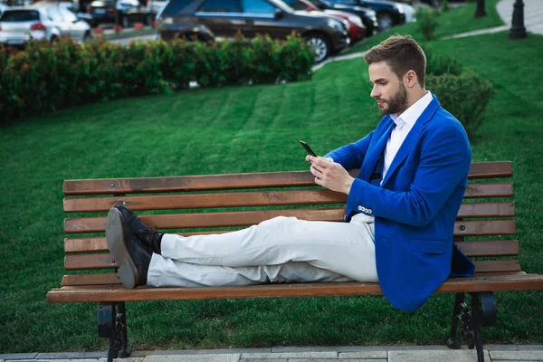 Neşeli adam ile smartphone Park'ta rahatlatıcı 