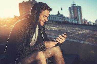 Sabah dışında mobil kullanan memnun adam 