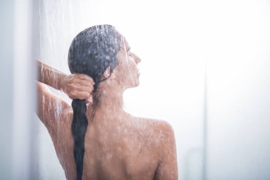 Serene female enjoying warm shower clipart