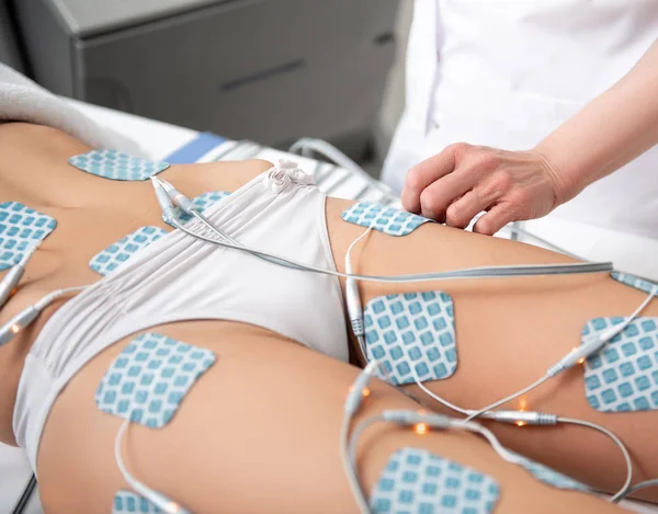 Doctor arm setting special appliance on client — Stock Photo, Image