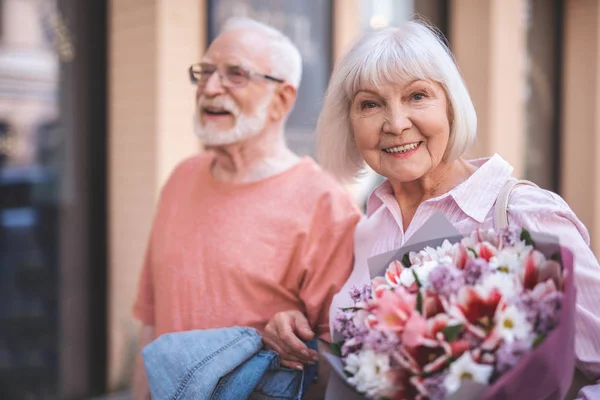 Delighted old woman walking with man on street — Stock Photo, Image