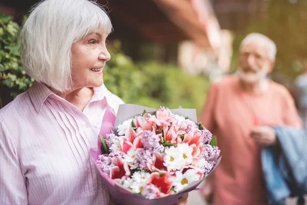 Verheugd vrouw met boeket buiten — Stockfoto