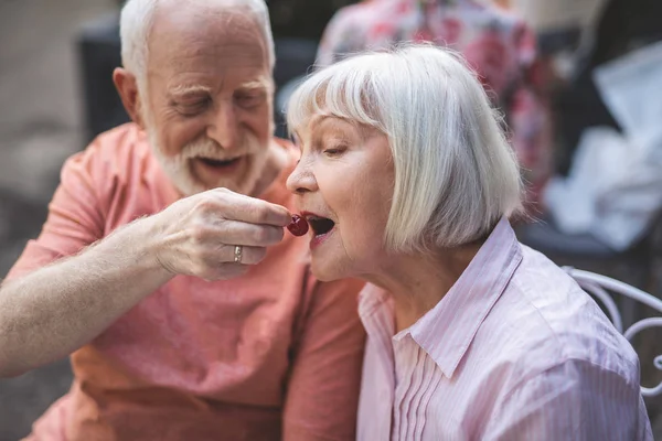 Feliz viejo alimentación esposa en café — Foto de Stock