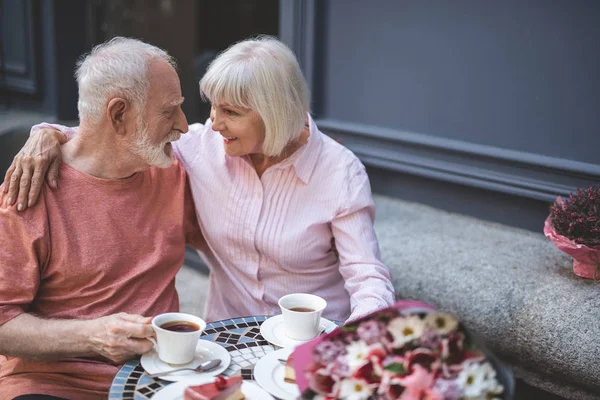 Pareja madura abrazándose en la cafetería con sonrisa — Foto de Stock