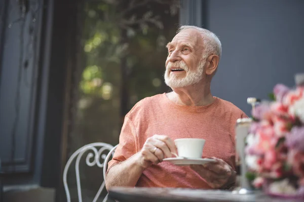 Alegre hombre mayor esperando a su cónyuge en la cafetería — Foto de Stock