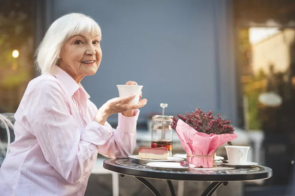 Viejo feliz hembra bebiendo bebida caliente afuera — Foto de Stock