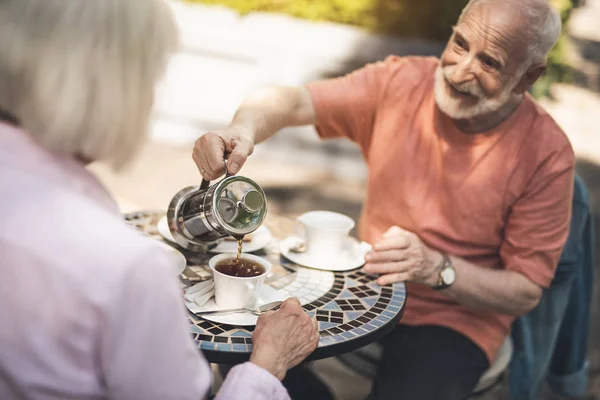 Sonriente hombre sosteniendo la tetera al aire libre — Foto de Stock