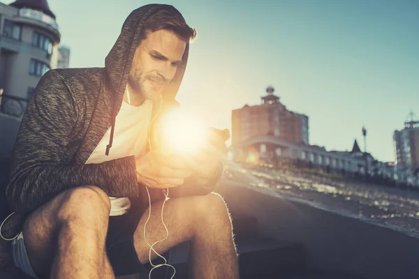 태양의 광선에서 음악을 듣고 하는 젊은 남자 — 스톡 사진