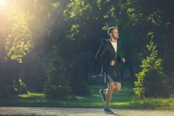 Joven deportista calentándose por la mañana — Foto de Stock