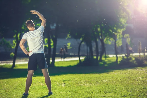 Välformade idrottsman tränar i park — Stockfoto