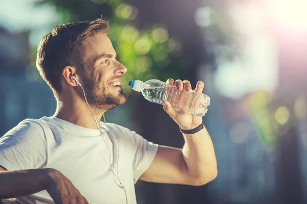 Lycklig man dricka efter jogging utanför — Stockfoto