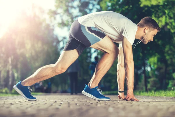 Muskulös atlet förbereder för race utomhus — Stockfoto