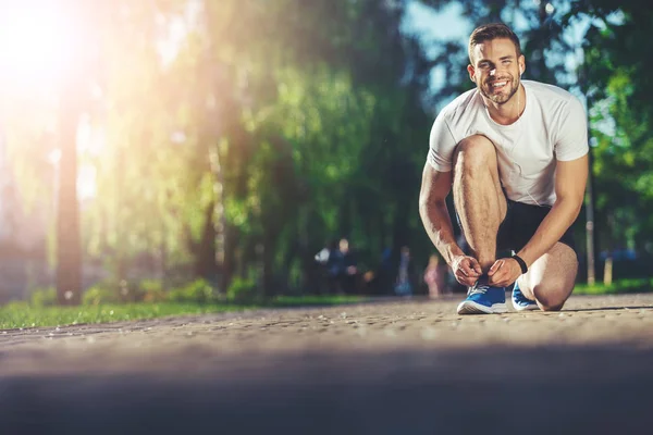 Happy sprinter tying snickers during running — Stock Photo, Image