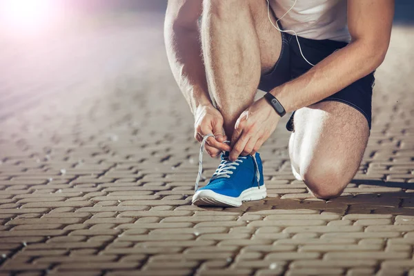 Fit atleet koppelverkoop schoen tijdens het hardlopen — Stockfoto