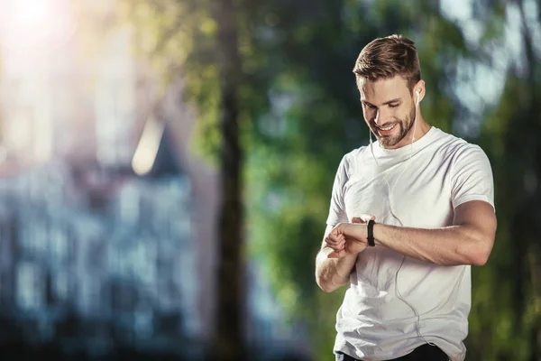 Χαρά αθλητή τον έλεγχο fitness tracker σε εξωτερικούς χώρους — Φωτογραφία Αρχείου