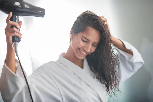 Šťastná dáma sušení vlasy s vybavením — Stock fotografie