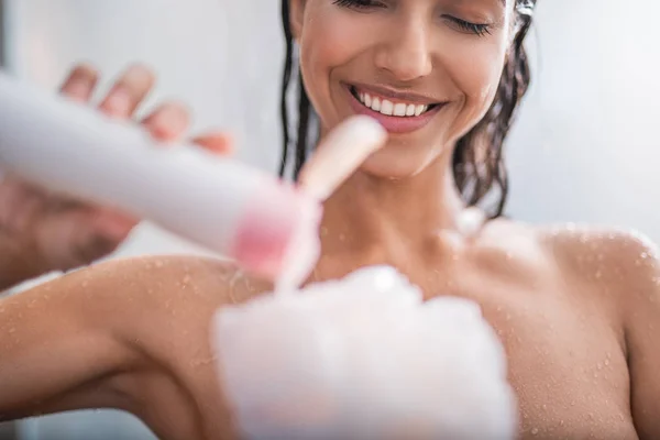 Beaming girl putting shower gel — Stock Photo, Image