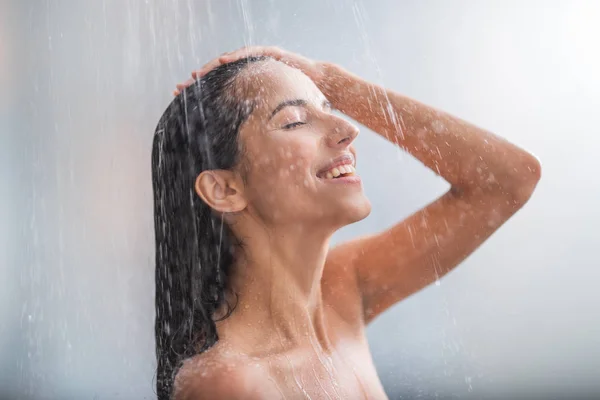 Mujer positiva tomando ducha caliente — Foto de Stock