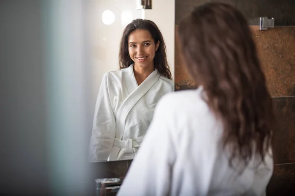 Улыбающаяся женщина смотрит на отражение — стоковое фото