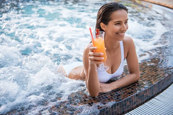 Glad lady tasting cocktail in swimming pool — Stock Photo, Image