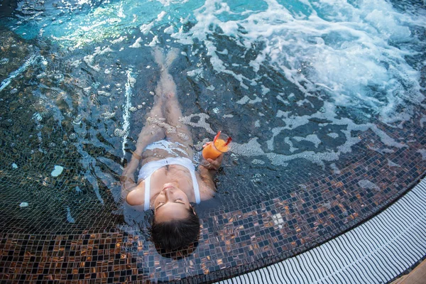 Yüzme havuzunda sıvı içme sakin kadın