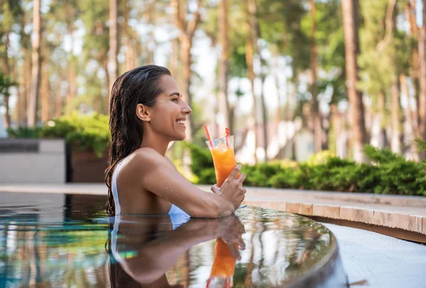 Positive female tasting juice in swimming pool — Stock Photo, Image