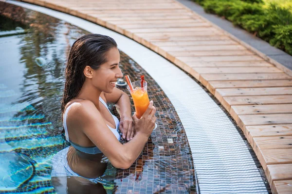 Cheerful female tasting cocktail in swimming pool — Stock Photo, Image