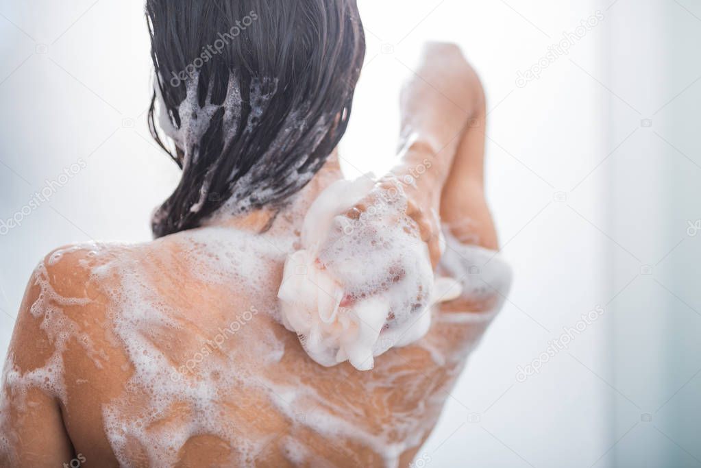 Woman rubbing body with foam
