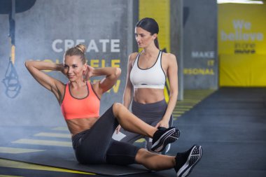 Gülümseyen kadın eğitim abs ile kalfa içinde jimnastik salonu olduğunu
