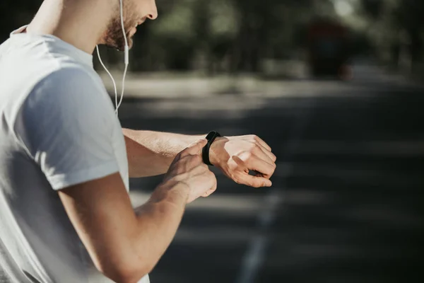 Glad sportsman kontrollera smartwatch på utbildning — Stockfoto