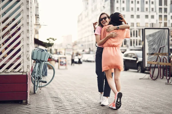 Knuffelen vrouwelijke vriend blij meisje — Stockfoto