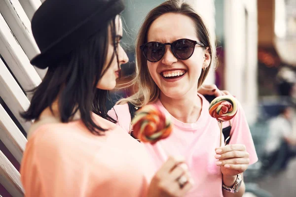 Felices hembras degustando piruletas en la calle —  Fotos de Stock