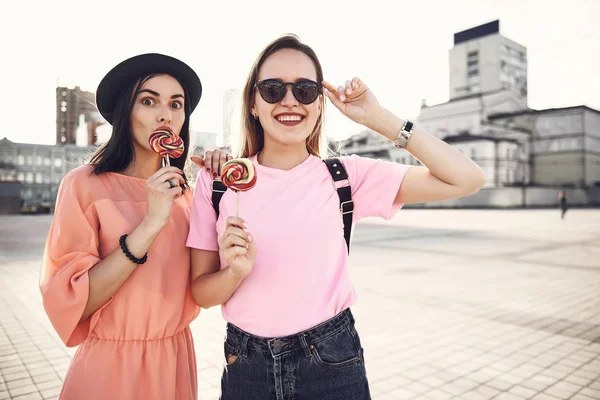 Mujeres optimistas degustando piruletas en la calle —  Fotos de Stock