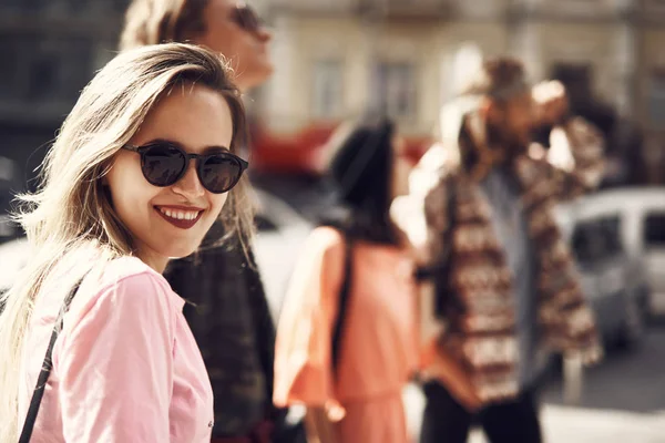 Mujer positiva dando vueltas por la ciudad con camaradas — Foto de Stock