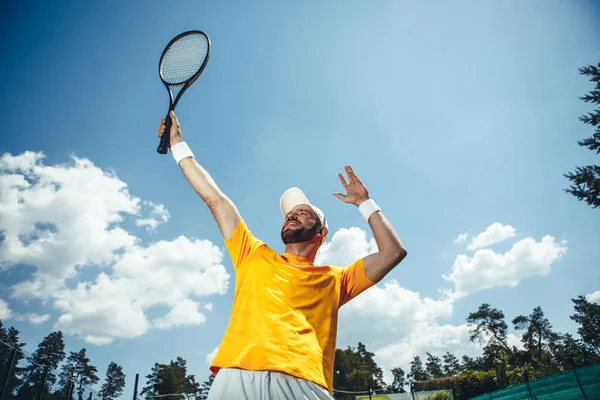 Усміхнений спортсмен жестикулює рукою з ракеткою — стокове фото