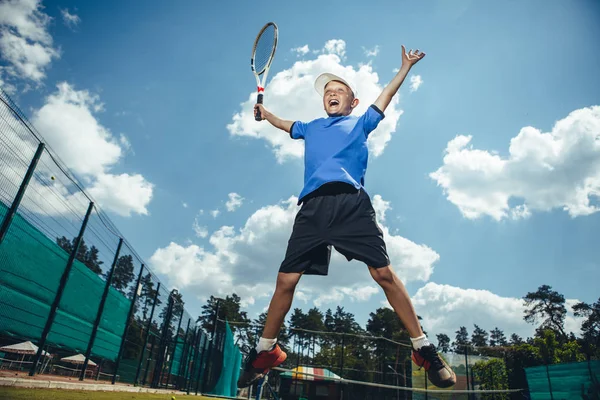Вихідний хлопчик грає в теніс на відкритому повітрі — стокове фото