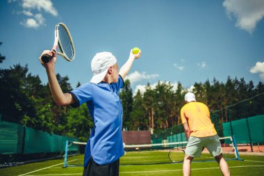 Çocuk ve adam tenis oynamaya