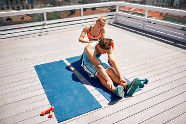 Neşeli kadın adam balkonda esneklik ile yardım