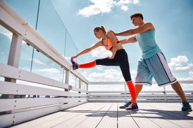 Erkek kız çatıda sırasında germe yardımcı oluyor