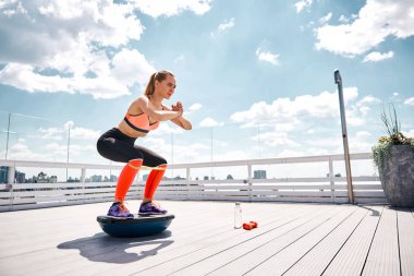 Neşeli kadın fitness ekipmanları güneşli terasta ile egzersiz
