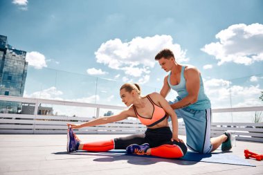 Sakin kadın çatıda eğitmen ile egzersiz