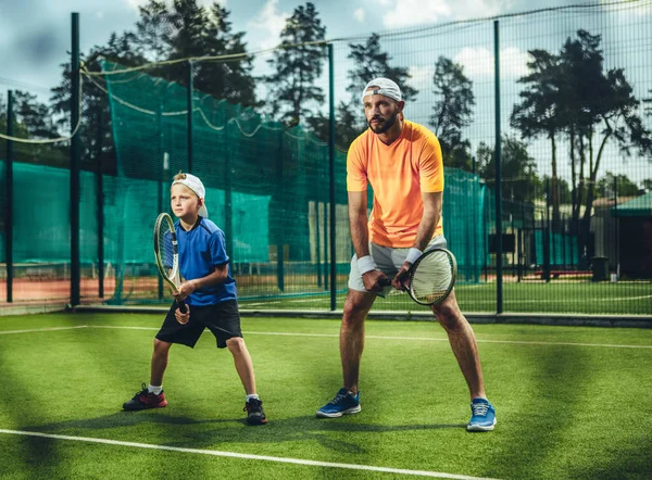 Чоловік і дитина грають в теніс на відкритому повітрі — стокове фото