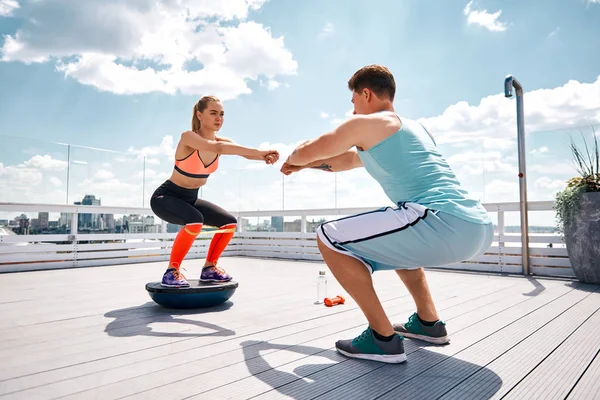 Hombre y mujer están haciendo ejercicio juntos en la azotea — Foto de Stock