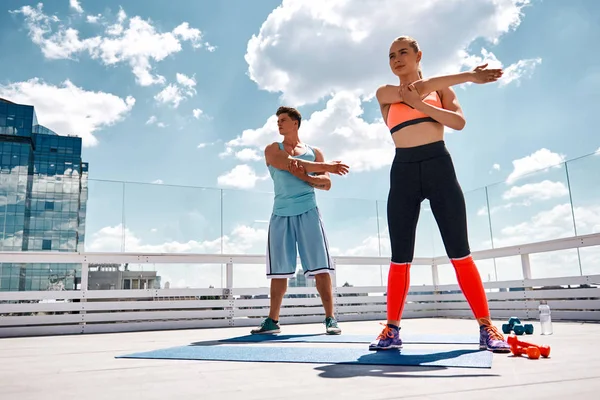 Pareja deportiva se prepara para el entrenamiento al aire libre — Foto de Stock