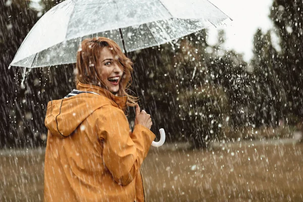 Fröhliche Frau geht bei regnerischem Wetter — Stockfoto