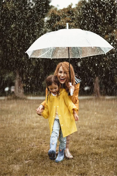 Mujer con niña pequeña admirando el clima lluvioso —  Fotos de Stock