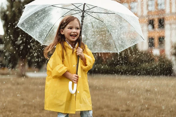 Счастливый ребенок наслаждается дождём на улице — стоковое фото